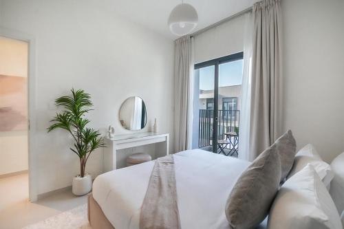 a white bedroom with a bed and a mirror at EasyGo- Lavish Townhouse with facilities in Dubai
