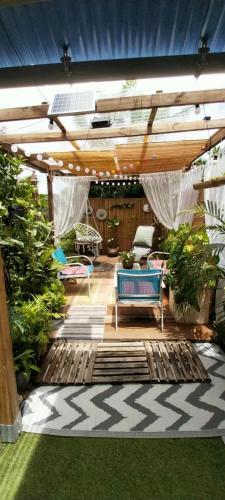 a patio with a deck with chairs and plants at Le LiloVert - Studio 24 m2 in Le Carbet