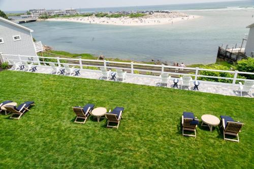 a group of chairs and tables on a lawn near the beach at Terrace By The Sea in Ogunquit