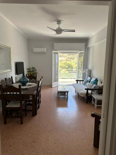 a living room with a table and a dining room at Sea view apartment steps away from the Beach Anavyssos Palyaia Fokia in Áyios Yeóryios