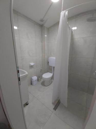 a white bathroom with a toilet and a shower at The Brothers Villa in Ohrid