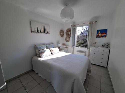 une chambre blanche avec un lit et une fenêtre dans l'établissement App Lou! AC, Pool, WiFi, Parking in Provence, au Luc