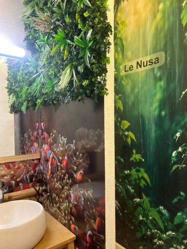 a bathroom with a wall mural of plants and a sink at Duplex Le Nusa in Perpignan