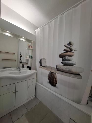 une salle de bain avec un lavabo et une baignoire avec des pierres dans l'établissement App Lou! AC, Pool, WiFi, Parking in Provence, au Luc