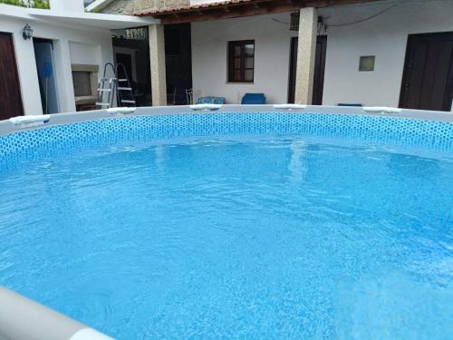 a large blue swimming pool in a house at Villa Cantinho dos Avós in Baião
