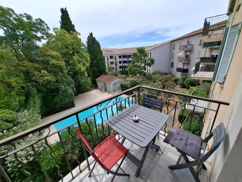 un balcon avec une table et des chaises sur un balcon dans l'établissement App Lou! AC, Pool, WiFi, Parking in Provence, au Luc