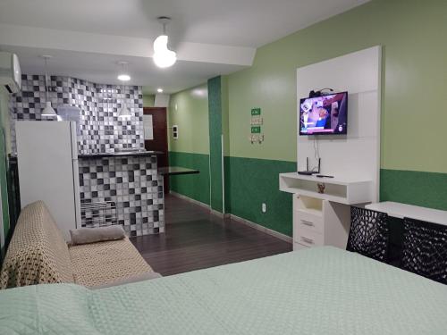 um quarto com uma cama e uma TV na parede em Loft Beira Mar Prainha wi-fi 600 megas apt 323 em Arraial do Cabo