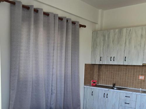 Villa E & M في فلوره: مطبخ مع ستائر رمادية ومغسلة