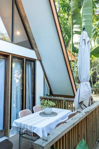 a table and umbrella on a balcony with a table and chairs at Casa Maria at Bigang Munti in San Juan