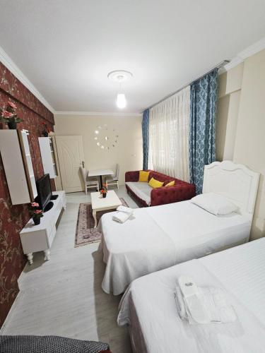 a hotel room with two beds and a couch at حكايه للشقق الفندقية الفاخره Hikaye Suites Hotel in Bostancı