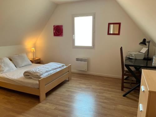 a bedroom with a bed and a desk and a window at Montagnac in Gignac