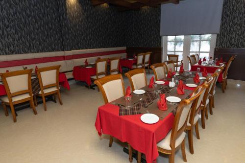 a dining room with tables and chairs with red table cloth at Hotel Luciya Palace in Trichūr