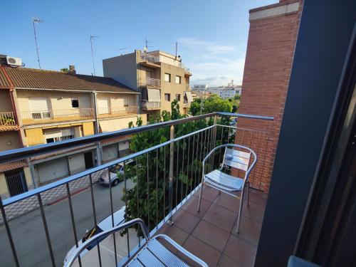 a balcony with two chairs and a brick building at Hostal Manel in Pineda de Mar