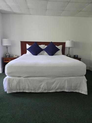 a bedroom with a large white bed with blue pillows at Terrace By The Sea in Ogunquit
