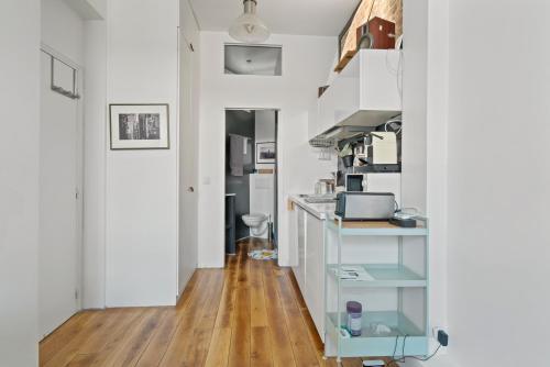 Il comprend une cuisine avec des murs blancs et du parquet. dans l'établissement Opera Cube, à Paris