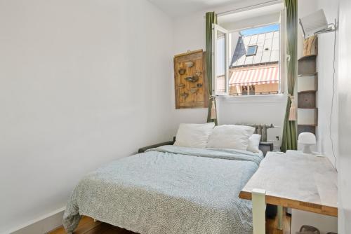 une petite chambre avec un lit et une fenêtre dans l'établissement Opera Cube, à Paris