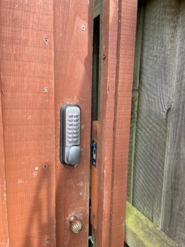 a wooden door with a remote control on it at Ferncroft Garden Studio in Histon