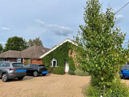a house with cars parked in front of it at Ferncroft Garden Studio in Histon