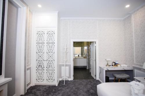 a white room with a bed and a desk at VARIMANTRA HOTEL in Nakhon Pathom