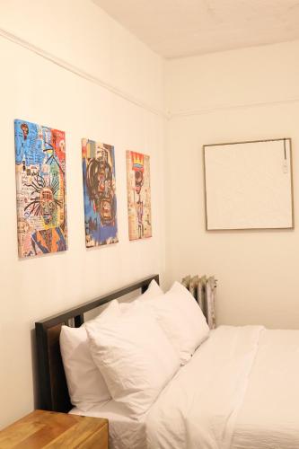 a bedroom with a bed and some pictures on the wall at Santa Cruz rooms and hospitality 