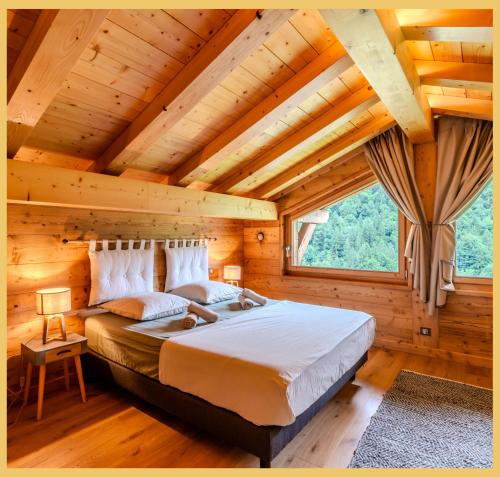 a bedroom with a large bed in a log cabin at Le Sylvana I T4 I Abondance in Abondance