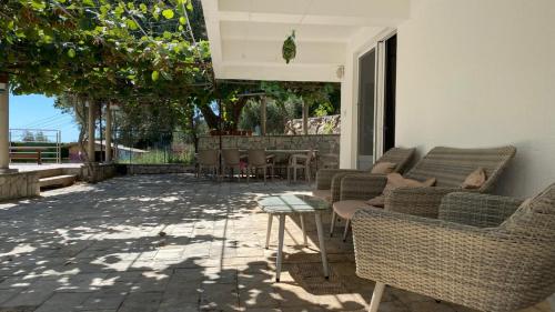 a patio with couches and a table and chairs at Villa Rezevici in Katun