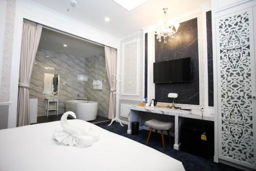a bedroom with a bed and a bathroom with a swan at VARIMANTRA HOTEL in Nakhon Pathom