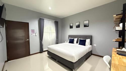a bedroom with a bed with blue pillows at B Villa 62 Rayong in Rayong