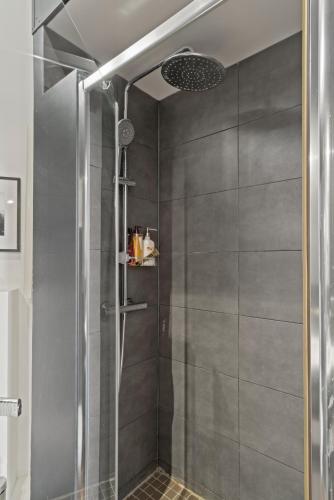 une douche avec une porte vitrée dans une salle de bain dans l'établissement Opera Cube, à Paris