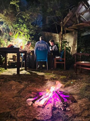 a fire pit in the yard with people sitting at a table at The Lake Frost in Nuwara Eliya