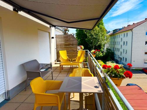 a balcony with yellow chairs and a table and chairs at Boardinghouse HOME - adults only - in Konstanz