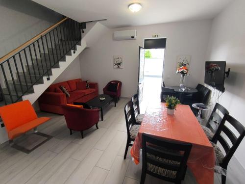 Una sala de estar con un sofá rojo y una mesa. en Tiny House, en Funchal