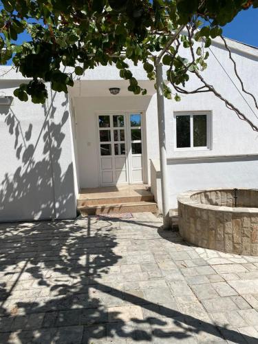 a white house with a white door and a tree at Villa Rezevici in Katun