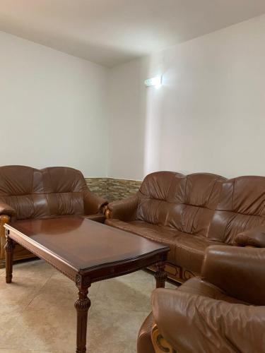 a living room with two brown leather couches and a coffee table at Villa Rezevici in Katun