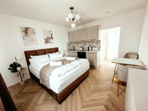 a bedroom with a large bed and a kitchen at Sali Homes - Wahnfried No 6 in Bayreuth