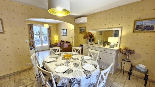 une salle à manger avec une table et une cuisine dans l'établissement La Palmyre - CHARMANTE MAISON INDIVIDUELLE classée 2 étoiles - accès WIFI, aux Mathes