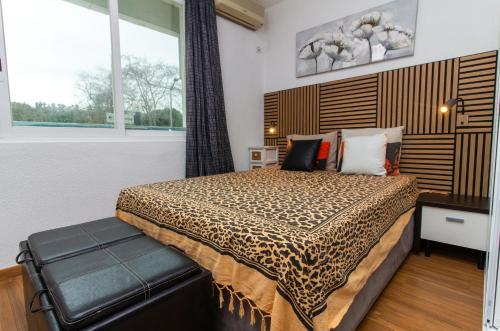 a bedroom with a bed and a large window at Bayview Old Town Beach Apartment in Albufeira