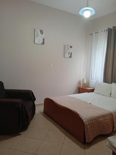 a bedroom with a bed and a chair in it at Gamila Sunrise in Konitsa