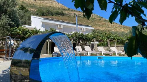 a pool with a water fountain in front of a house at Villa Rezevici in Katun