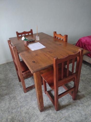 a wooden table with two chairs and a table with papers on it at El CAMPITO in La Ramada