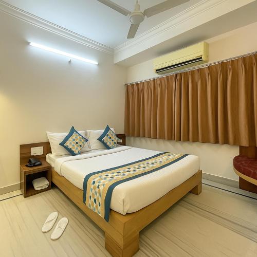 a bedroom with a large bed with blue pillows at The Sky Comfort Hotel Shreenath - 10 Meters from Shreenathji Temple in Nāthdwāra