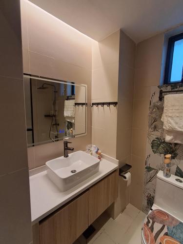 a bathroom with a sink and a mirror and a toilet at Favorite Staycation by Janice - Modern Comfort Near Airport in Nairobi
