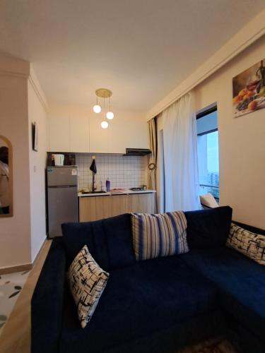 a living room with a blue couch and a kitchen at Favorite Staycation by Janice - Modern Comfort Near Airport in Nairobi