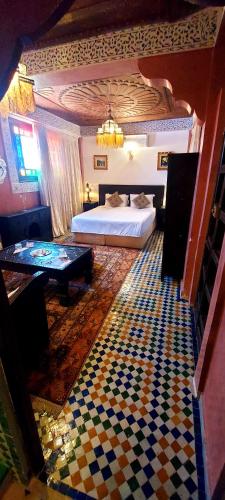 a hotel room with a bed and a table at Palais AL Firdaous in Fès