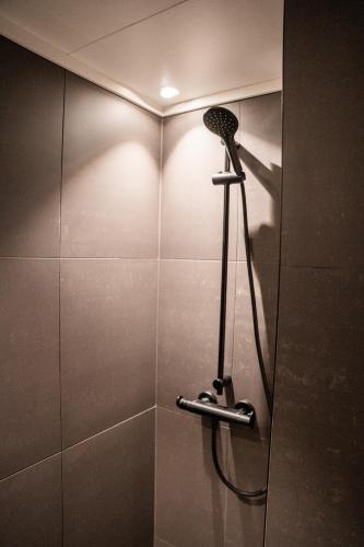 a shower with a shower head in a bathroom at Hemsedal Cafe Skiers Lodge in Hemsedal