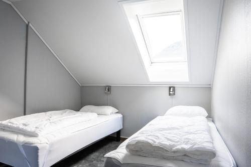 two beds in a small room with a window at Hemsedal Cafe Skiers Lodge in Hemsedal