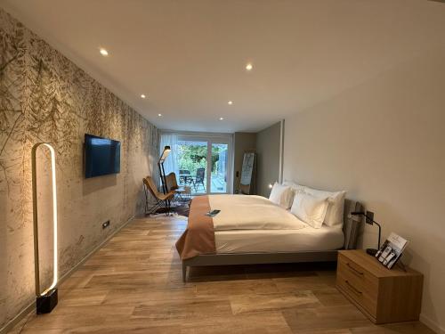 a bedroom with a bed and a tv on a wall at LA VILLA - by Hotel Remorino in Locarno
