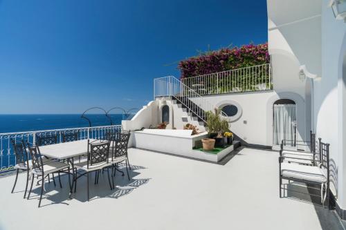 a balcony with a table and chairs and the ocean at Villa Magia in Positano