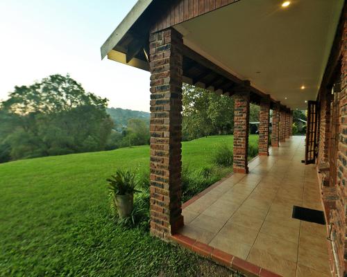 a brick building with a walkway next to a green field at Chillifields Guesthouse in Hillcrest
