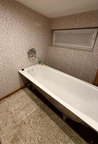 a white bath tub in a bathroom with a window at CENTRO House in Alytus